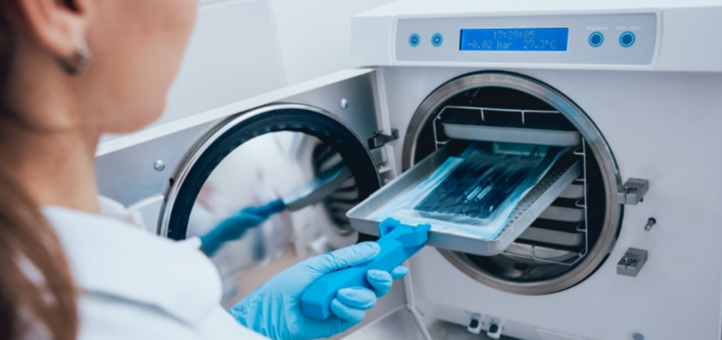 Dental assistant sterilizing instruments to meet OSHA dental infection control standards