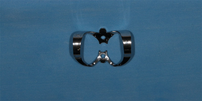 efrver No. 9 rubber dam clamp used for anterior tooth isolation and soft tissue retraction.