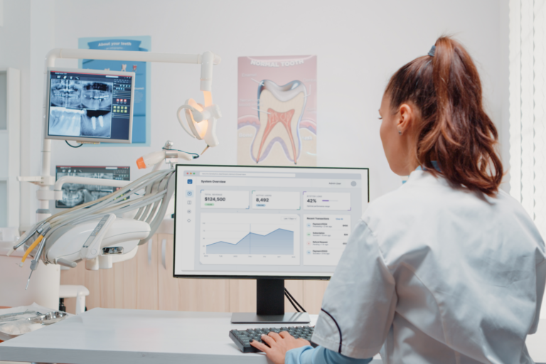 Dentist reviewing a dental practice metrics dashboard to monitor practice performance and key business indicators.