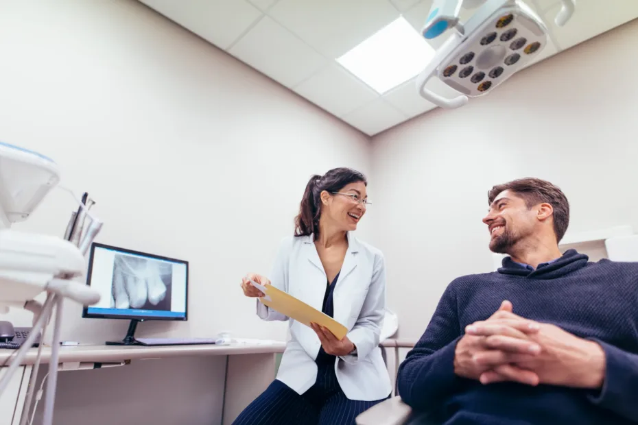 Flexible learning for real life Dentist holding a clipboard talking with a smiling patient in the dental chair